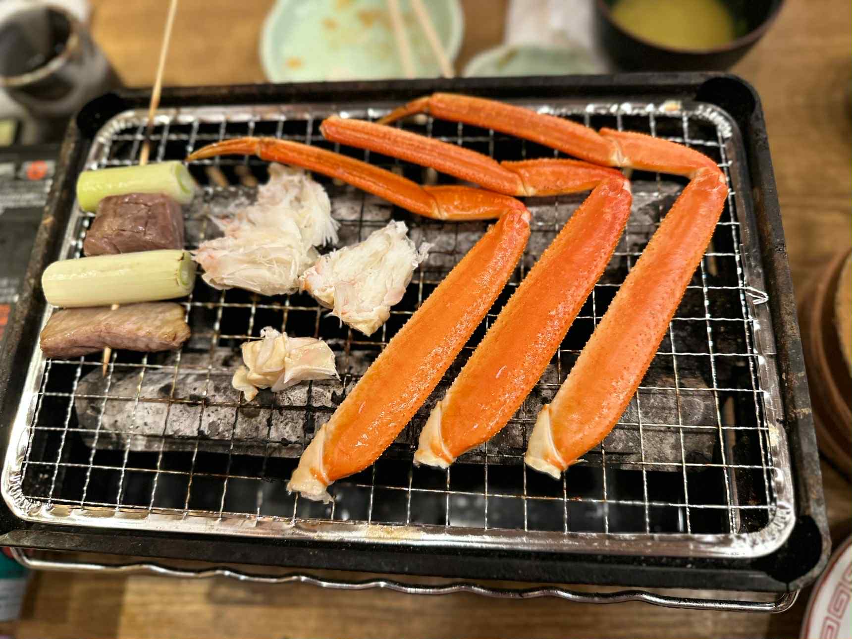 ขาปูย่างบนเตา มีเนื้อปูและต้นหอมญี่ปุ่น ขับรถเที่ยวคิวชู
